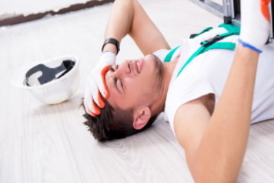 A worker is on the floor holding his head injured.