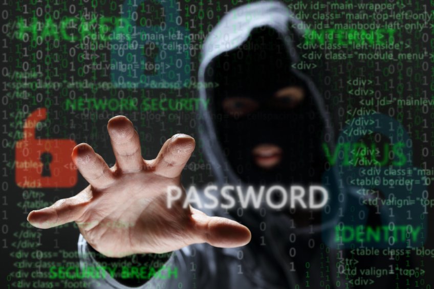 A shadowy man in a hoody with his hand stretched over the word 'password' on a background with green letters and the word 'hacker', 'internet', 'virus' and 'identity' dominating.
